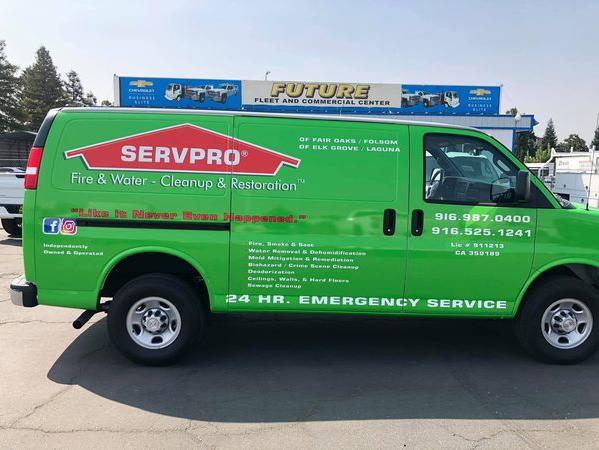 Bright green Chevy Express van with local business graphics