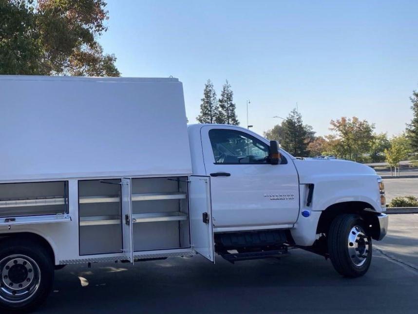 White Chevy Silverado 5500HD with Royal RSV Service Body, seen from the side with storage compartments open