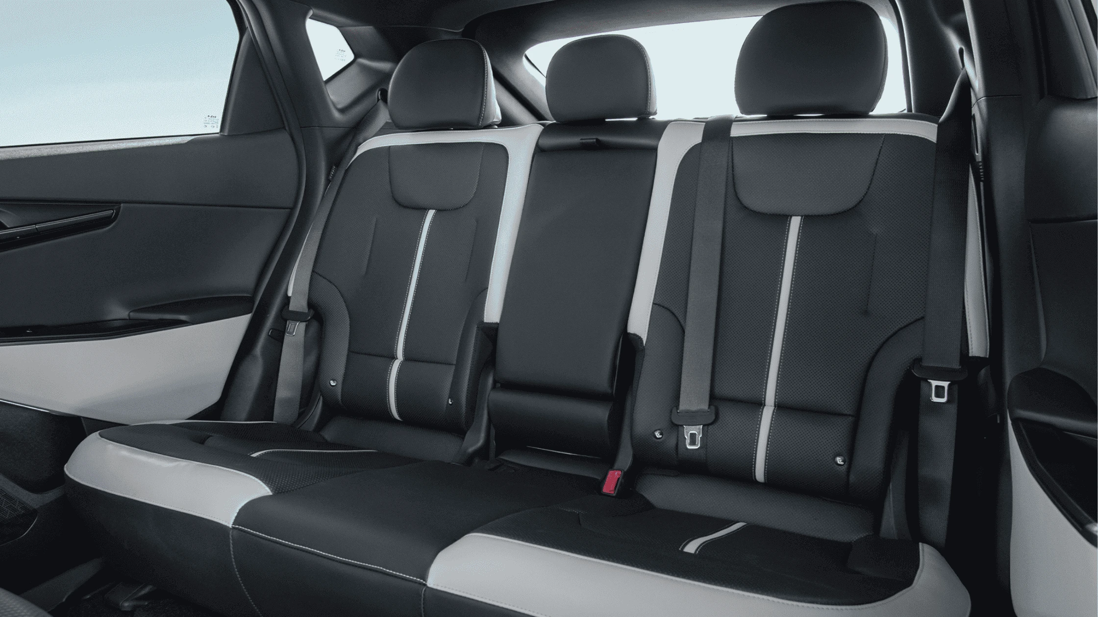 2025 Kia EV6 - Innovative Interior and Connectivity The rear seats of the 2025 Kia EV6 showcase a stylish black and white two-tone design with integrated seat belts, offering premium comfort and modern aesthetics for passengers.