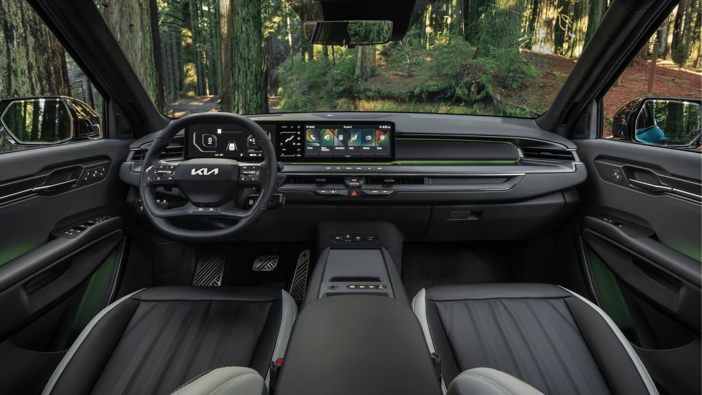 2025 Kia EV9 - Interior Layout and Passenger Configuration 2025 Kia EV9 driver cabin with dual screens and ambient green lighting