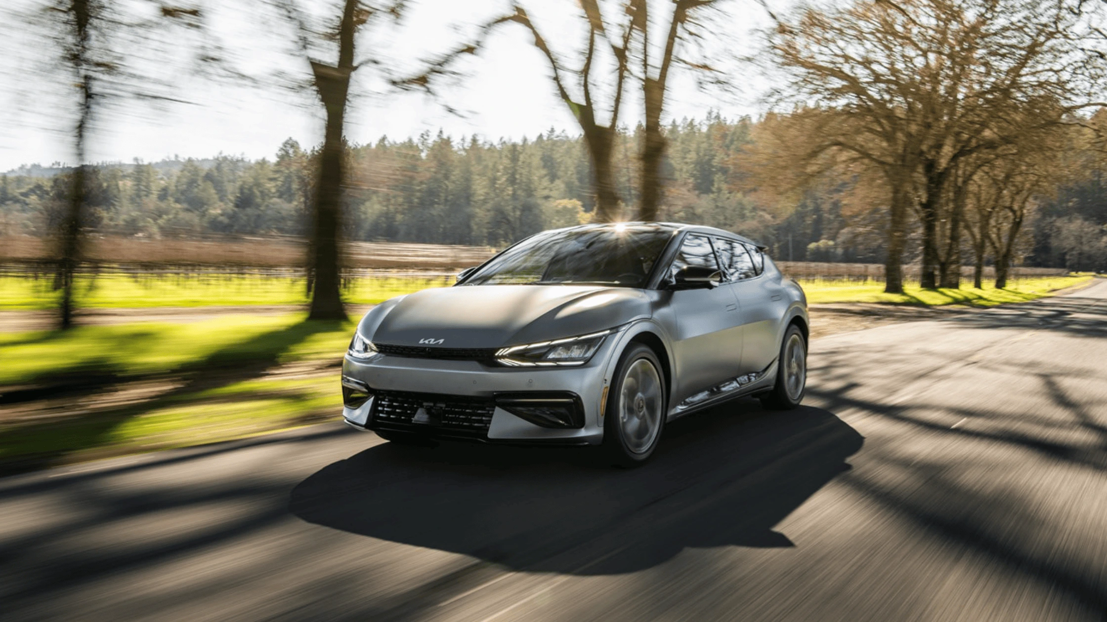 The 2024 Kia EV6 near Naples, FL The 2024 Kia EV6 electric vehicle driving on a scenic road near Naples, FL, showcasing its sleek design and eco-friendly performance.