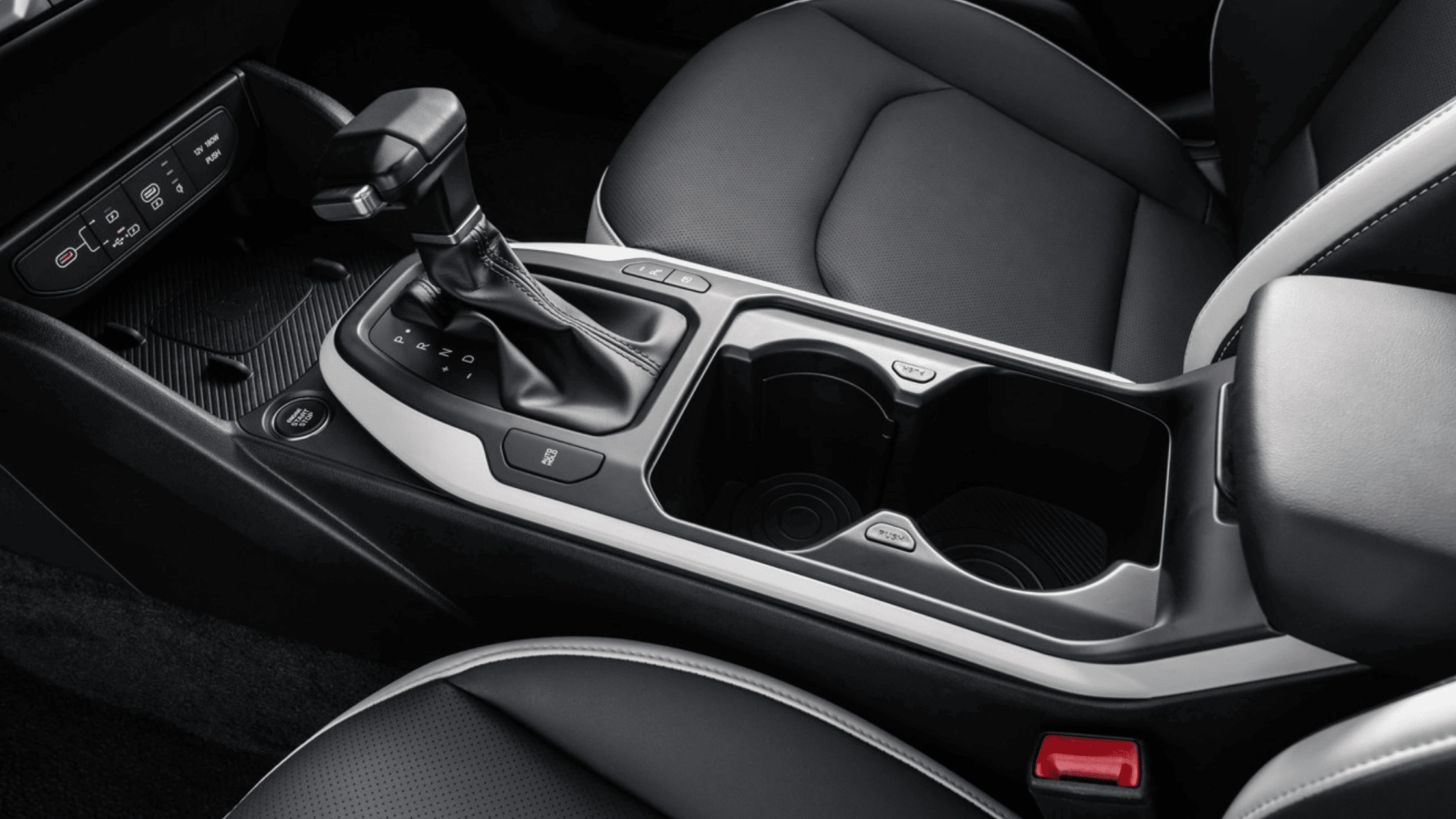 The 2025 Kia K4 - Technology Designed for Connectivity and Safety Close-up of the 2025 Kia K4 center console featuring a sleek gear shift, cup holders, and digital controls in Fort Myers, FL.