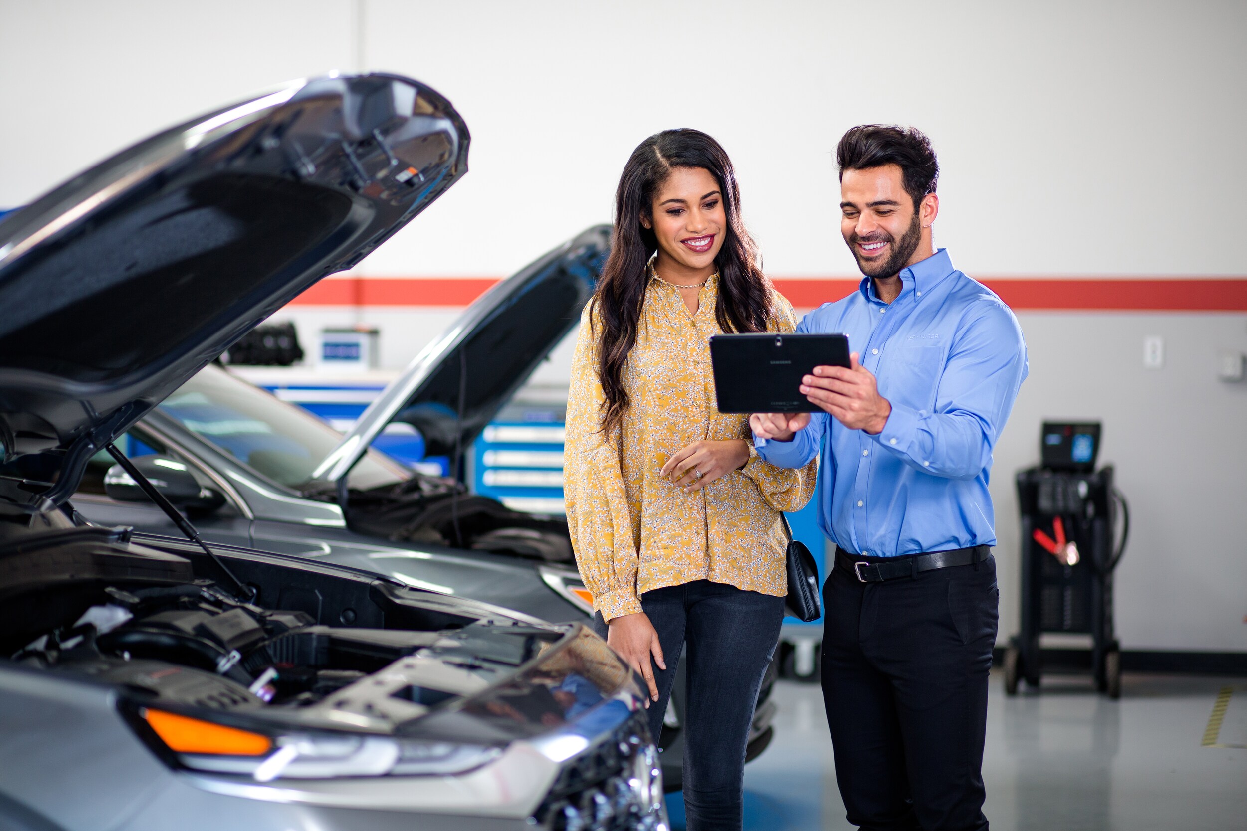 Hyundai technician showing customer details after car inspection