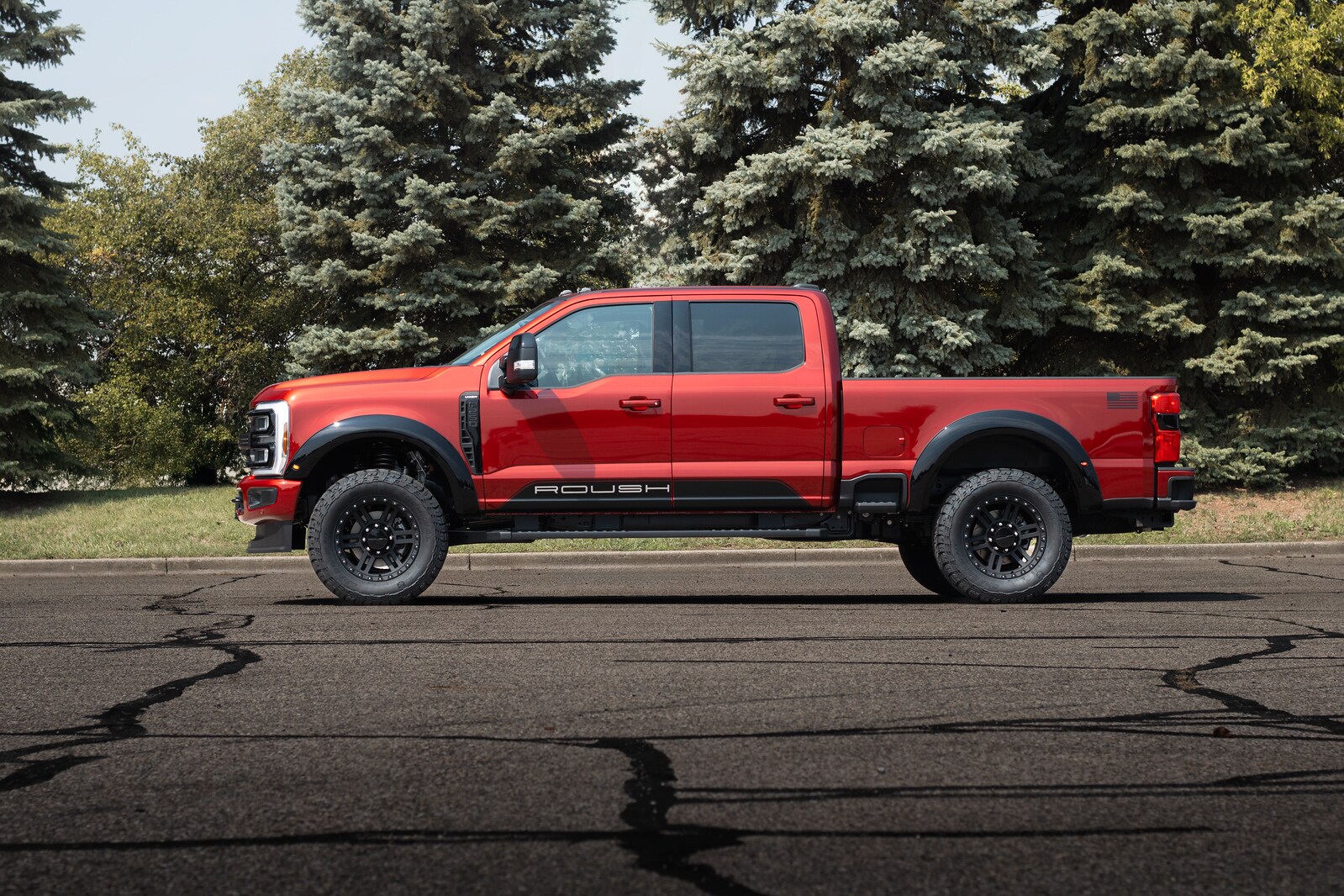 Ruby Red ROUSH Super Duty crew cab side profile with ROUSH rocker graphic and black flares