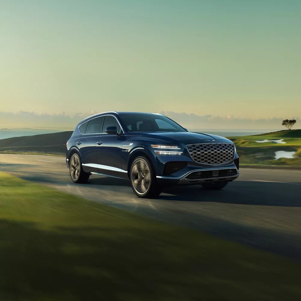 new Genesis GV80 driving on a road by a field new Genesis GV80 driving on a road by a field