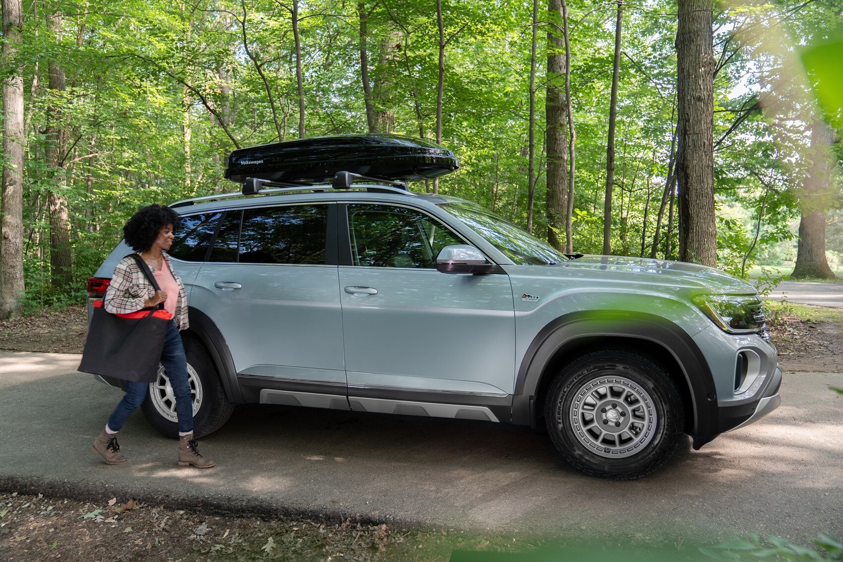 Woman walking next to Volkswagen Atlas parked in the woods from Volkswagen Dealer near Fair Lawn NJ