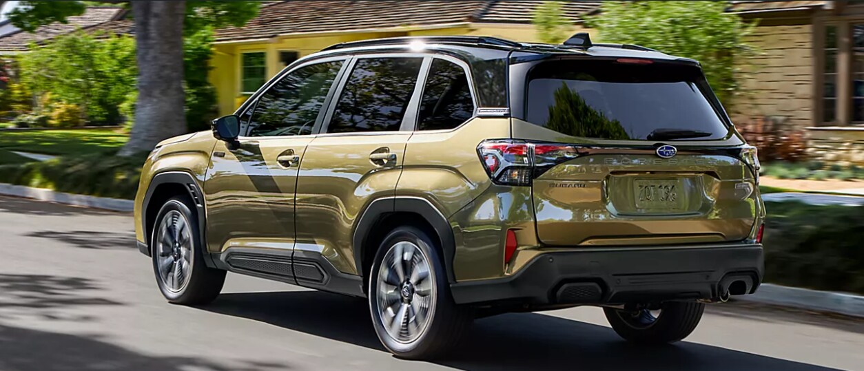 2025%20Forester%20Hybrid%20Performance%20Engine.webp Green Subaru driving on a city road.