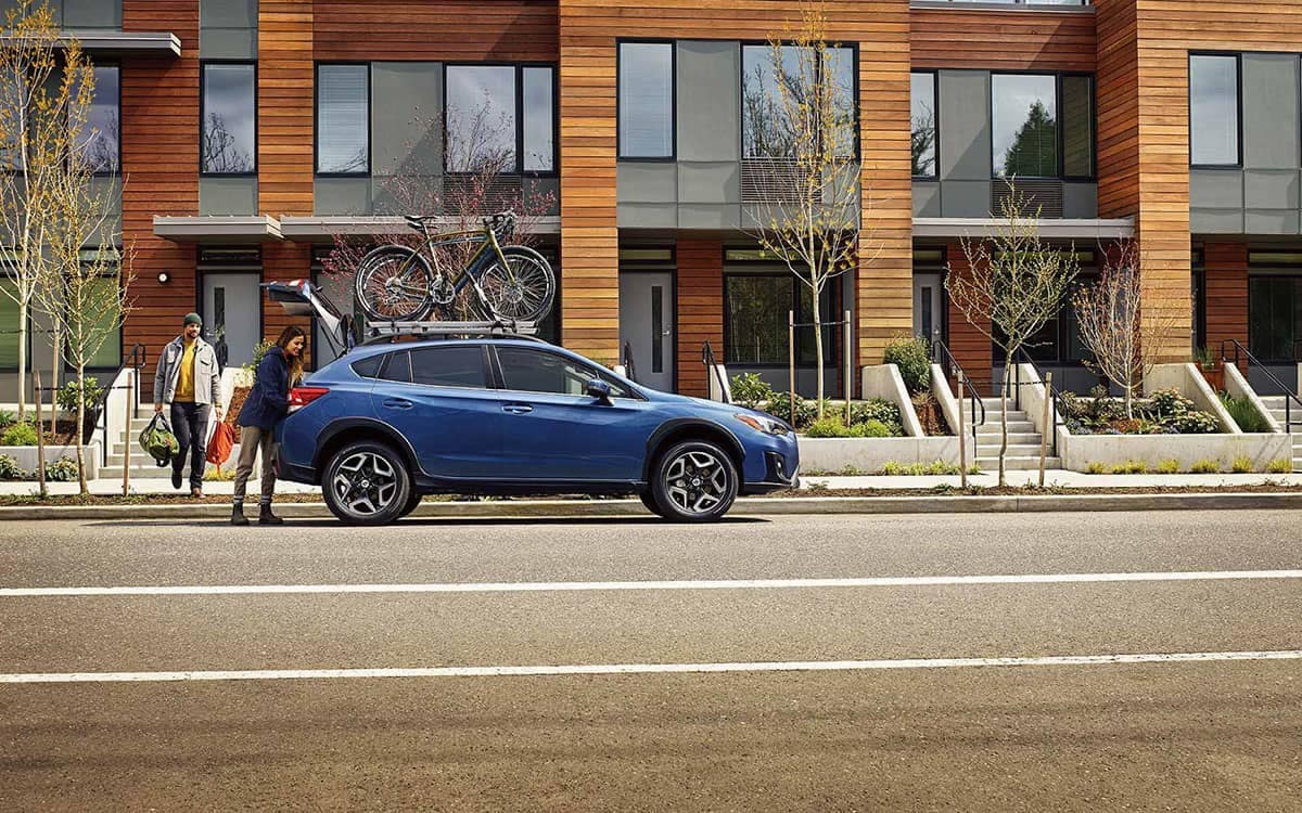 Couple Loading Cargo Area of 2019 Subaru Crosstrek Parked Outside Condos