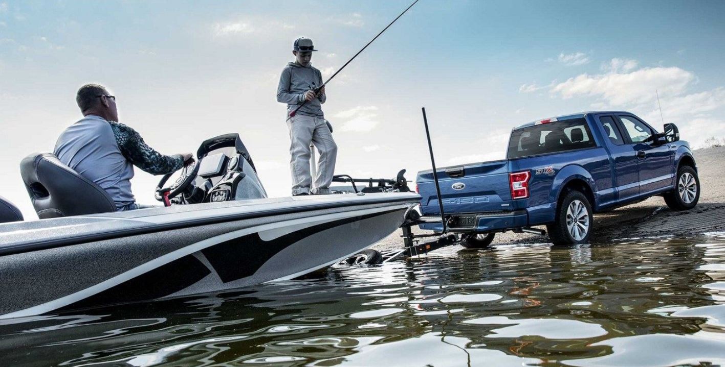 Ford F-150 pushing a boat into the water.