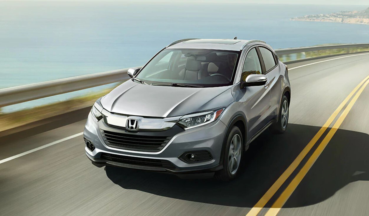 Learn more about the 2022 Honda HR-V's fuel efficiency at AutoNation Honda East Las Vegas A Honda HR-V driving down the highway near the ocean