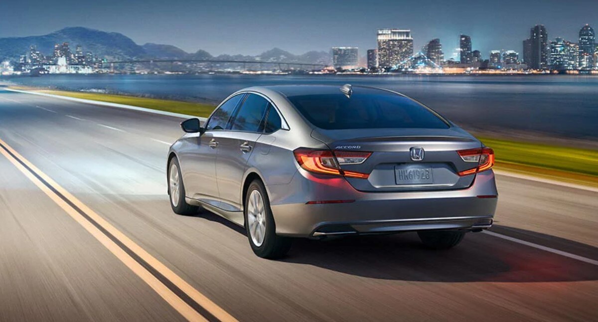 Learn more about the 2022 Honda Accord's fuel efficiency at AutoNation Honda East Las Vegas Honda Accord driving at night on the highway toward a city