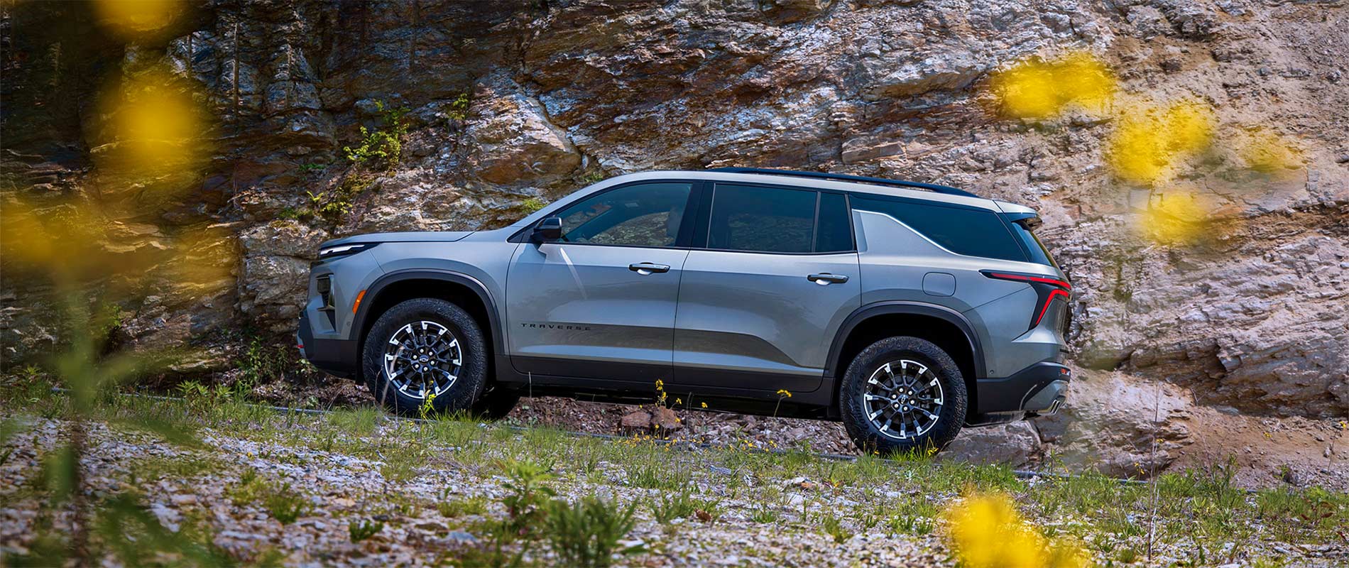 2026 Chevy Traverse Trim Comparison A gray 2026 Chevy Traverse parked off-road by a rock wall.