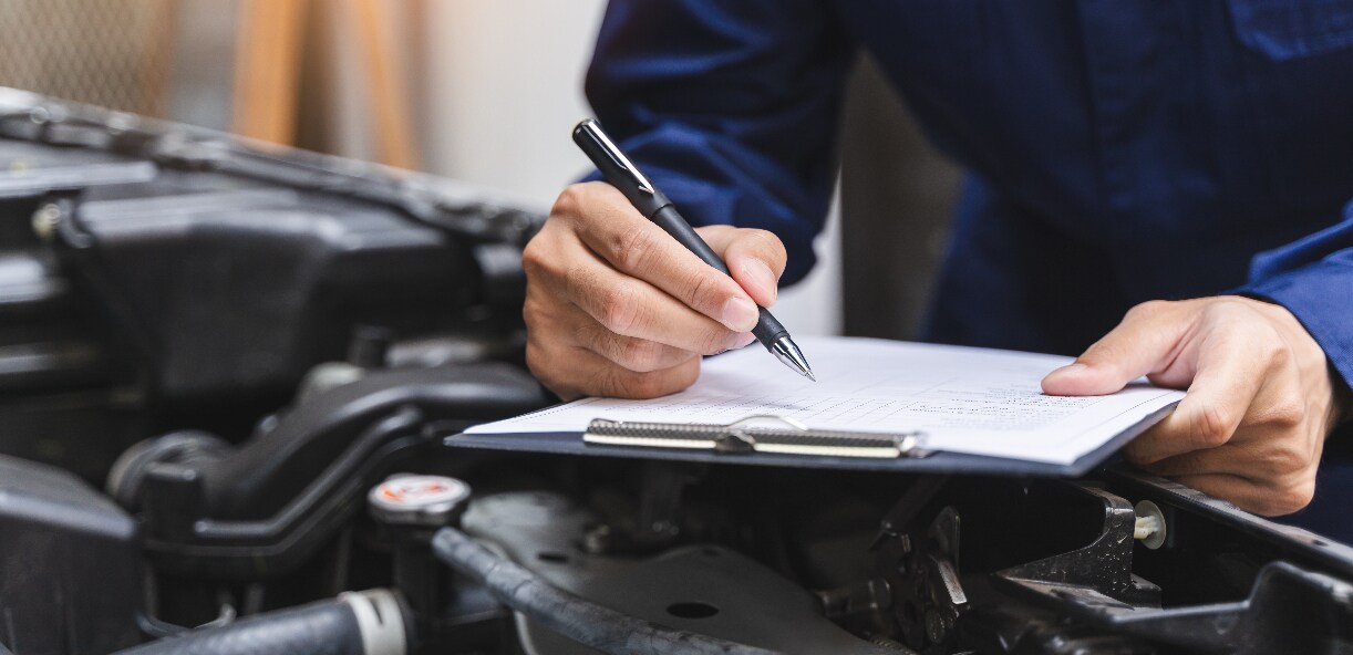 A technician going over a vehicle maintenance checklist. A technician going over a vehicle maintenance checklist.