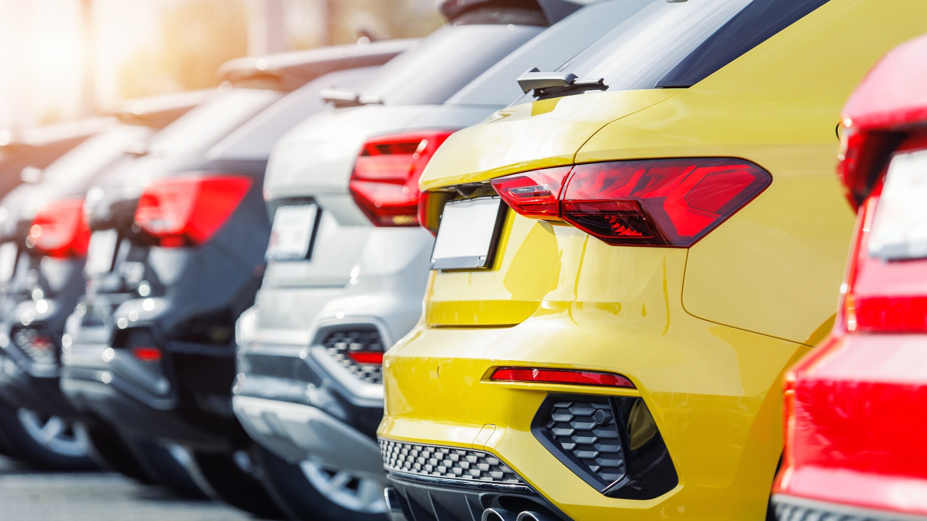 A rear view of different-colored SUVs at a dealership lot. A rear view of different-colored SUVs at a dealership lot.