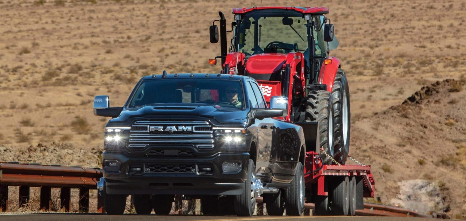 Commercial Vehicle Dealer Near Me A black RAM 3500 towing a red tractor on a car hauler trailer.