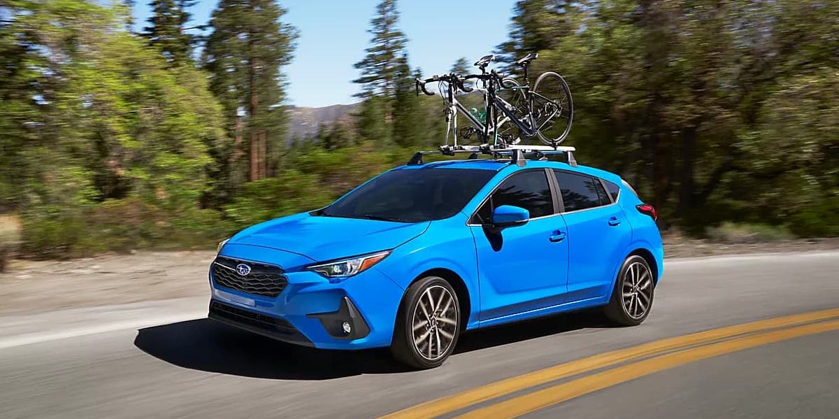Blue 2024 Subaru Impreza with a roof rack