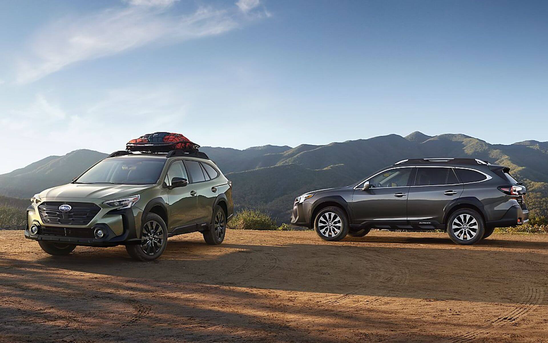 22_OBK_photos_ext_02.jpg two 2023 Subaru Outbacks parked in the mountains with camping gear on top of one car