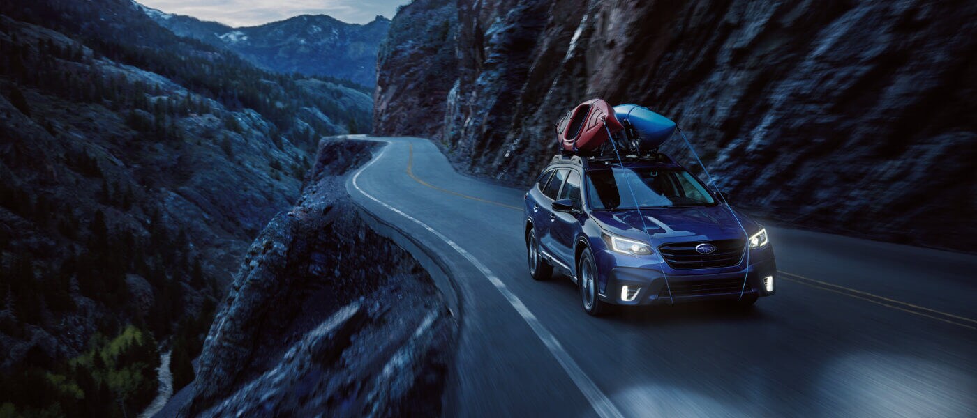 2020 Subaru Outback driving next to a cliffside