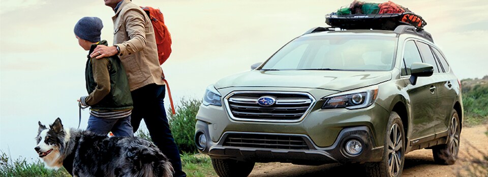 2019 Subaru Outback near father, son, and dog