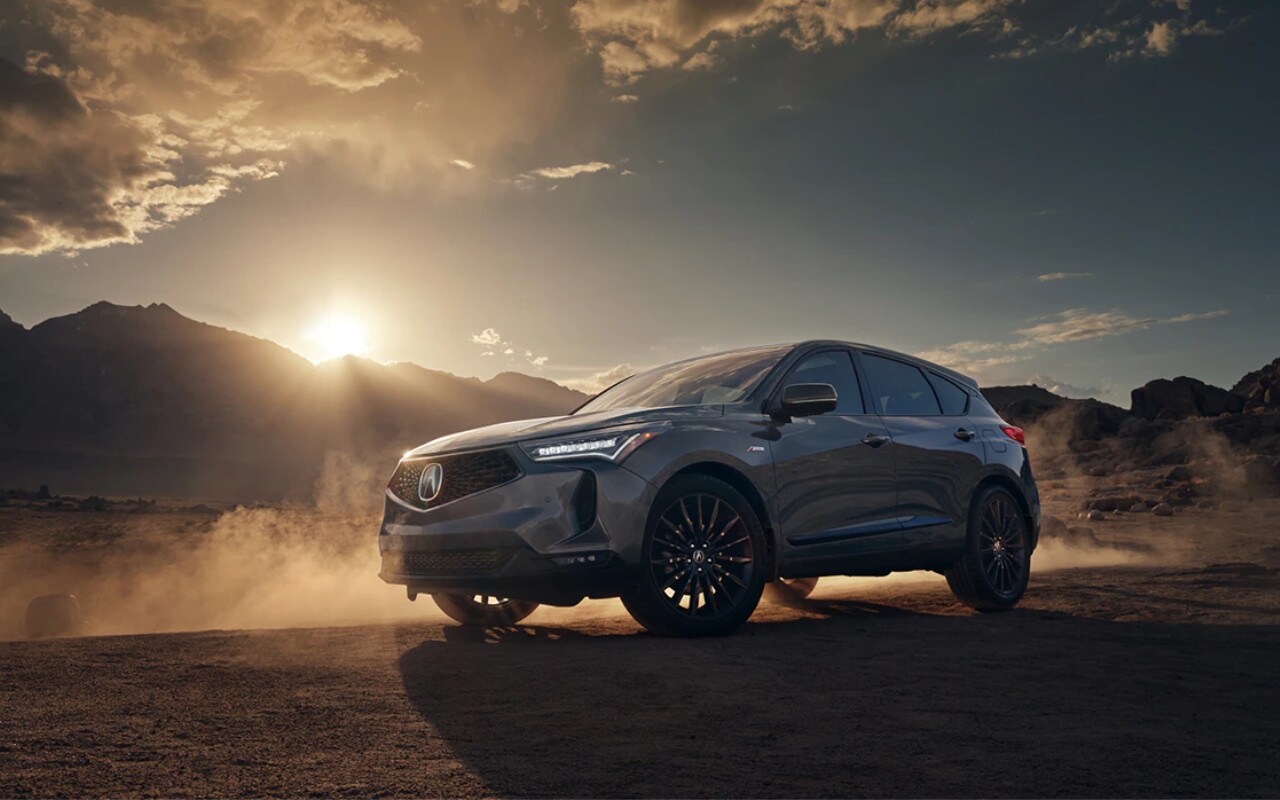 vue latérale avant d'une Acura RDX 2023 devant une montagne au crépuscule