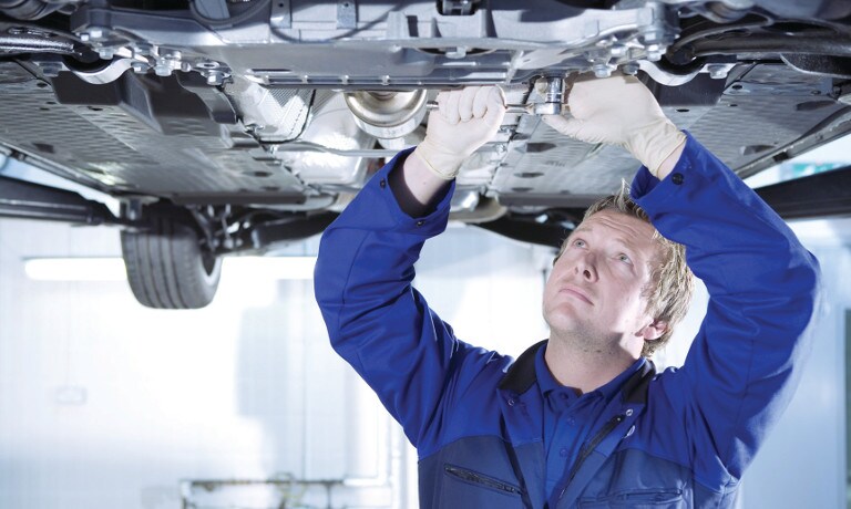 A mechanic working underneath car
