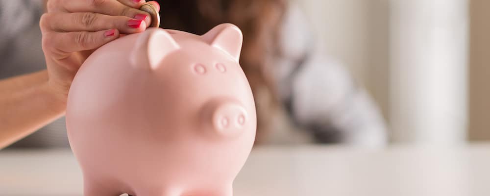 Hand putting money into piggybank
