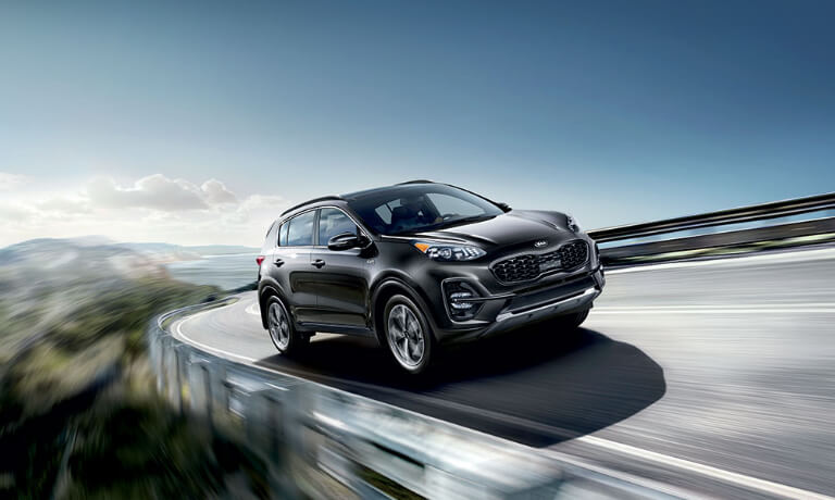 2020 Kia Sportage in black driving on highway driving on the mountian