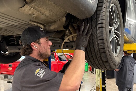 Technician performing brake and brake fluid inspection at Guaranty Chevrolet
