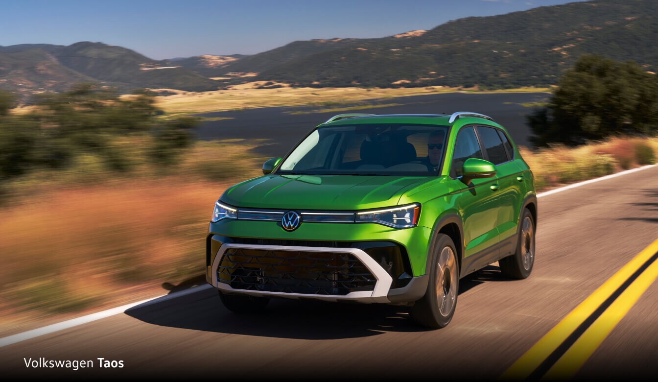 Three quarter front view of a Volkswagen Taos driving down a freeway
