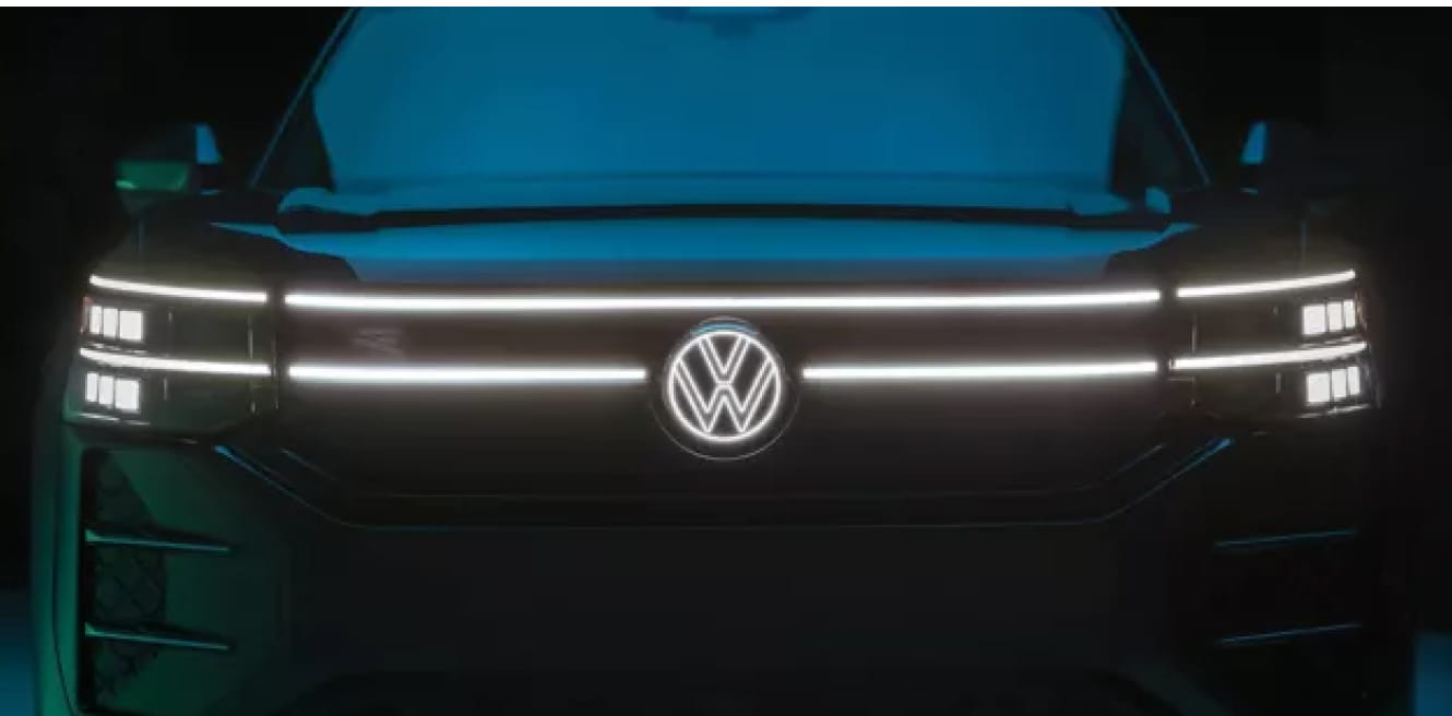 Front view of the 2027 Volkswagen Atlas highlighting its illuminated grille, LED headlights, and illuminated Volkswagen emblem.
