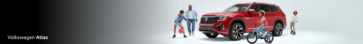 Family playing around the Volkswagen Atlas