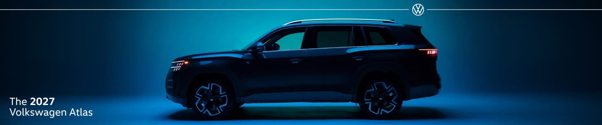 Side profile of the 2027 Volkswagen Atlas on a blue illuminated studio background.