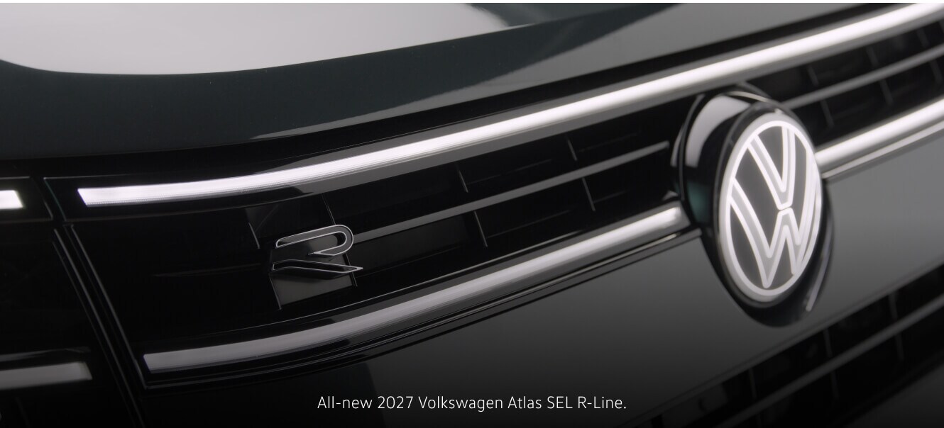 Close-up front view of a 2027 Volkswagen Atlas SEL R-Line highlighting its illuminated logo.