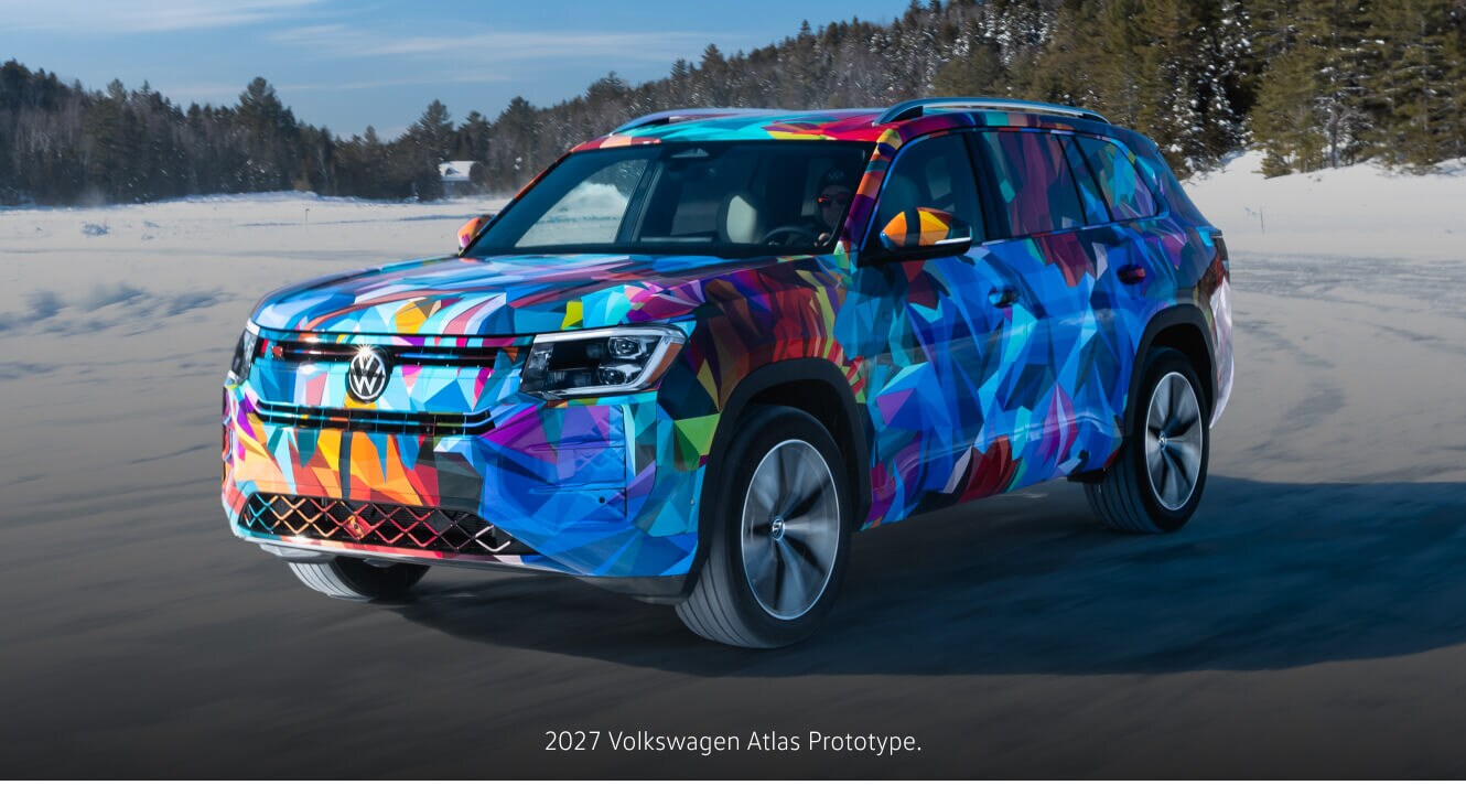 Three-quarter front view of a 2027 Volkswagen Atlas Prototype driving over a snow field.