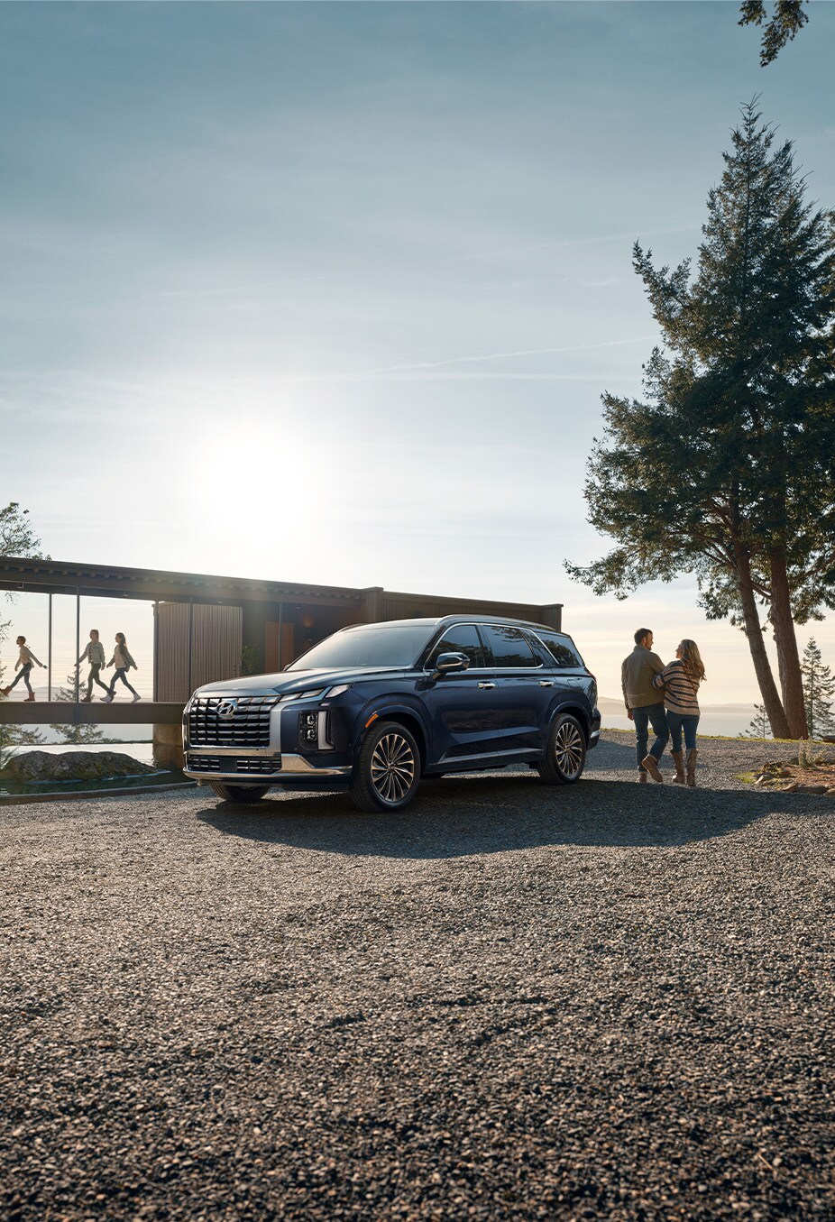 All-New 2023 Hyundai Palisade at Haddad Hyundai | 2023 Hyundai Palisade parked outside on driveway with family walking around