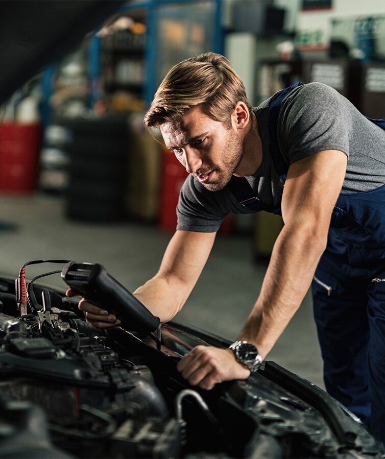 Protect Your Hyundai at Haddad Hyundai in Pittsfield, MA | Mechanic using computer tool to scan the system software of a vehicle