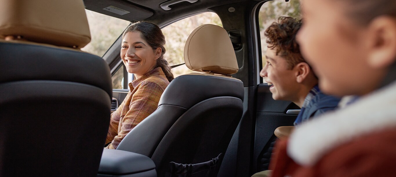 2023 Hyundai Santa Fe at Haddad Hyundai | Woman and kids smiling and laughing inside of a 2023 Santa Fe