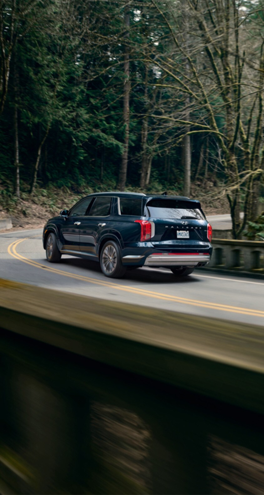 All-New 2023 Hyundai Palisade at Haddad Hyundai | Rear profile of a 2023 Hyundai Palisade driving down the road