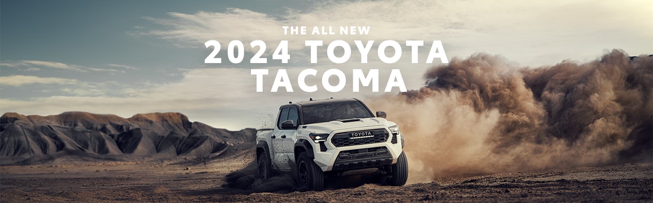 2024 Toyota Tacoma at Haddad Toyota in Pittsfield, MA | White 2024 Toyota Tacoma driving in the dirt