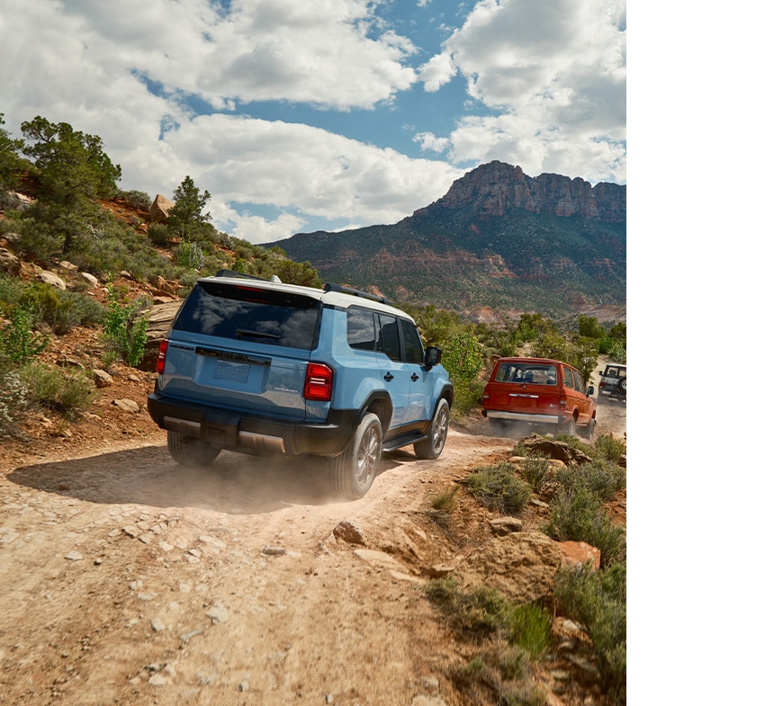 2024 Toyota Land Cruiser at Haddad Toyota in Pittsfield, MA | Rear profile of a 2024 Toyota Land Cruiser driving down a dirt road