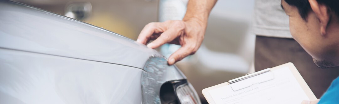 Car with dent below the headlight