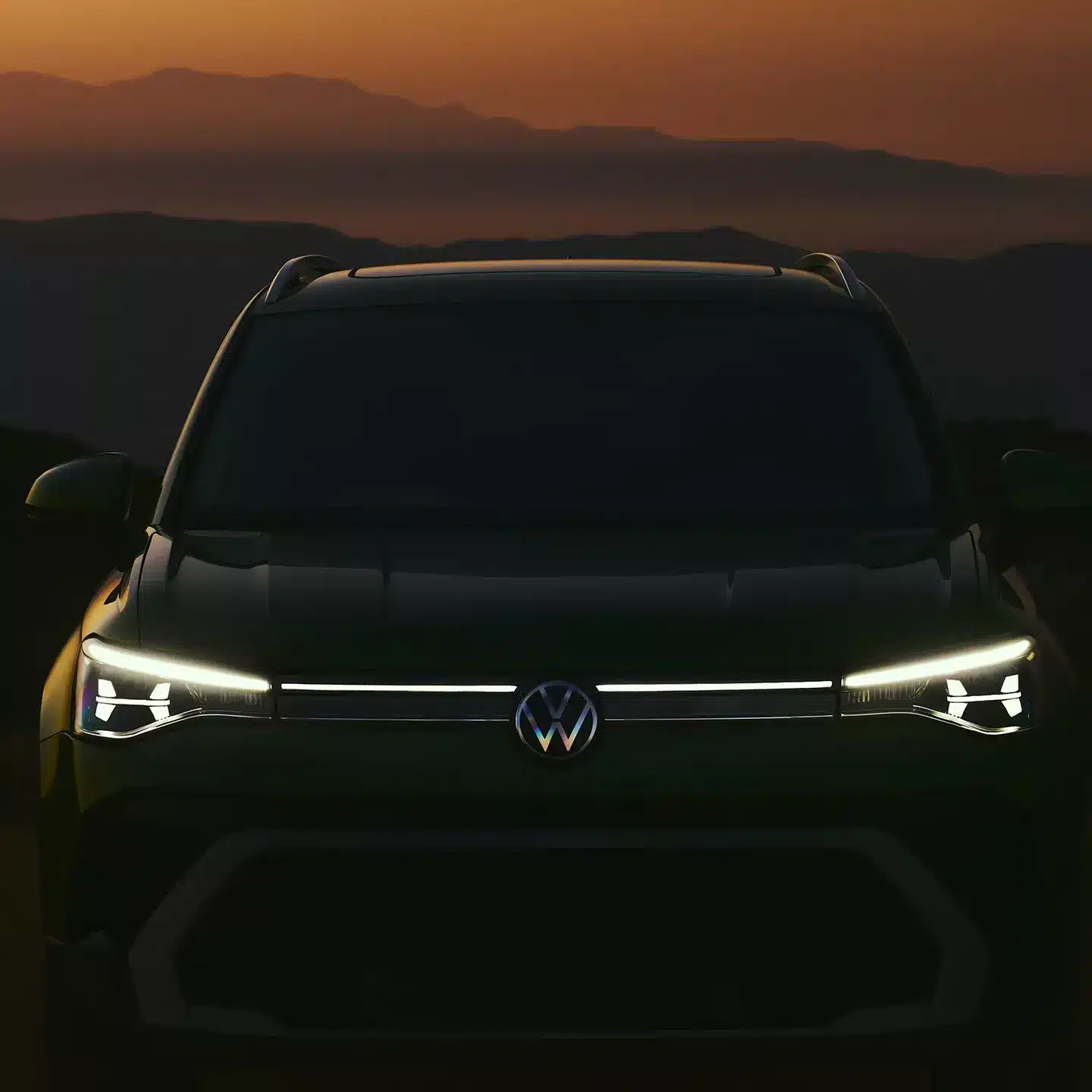 A close-up, head-on view of the illuminated front grille and headlights of the 2026 Volkswagen Taos SUV