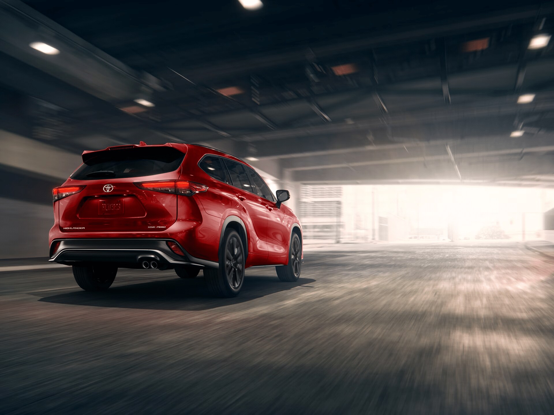 2026 Toyota Highlander driving through a Pacific Northwest setting, emphasizing its capability.