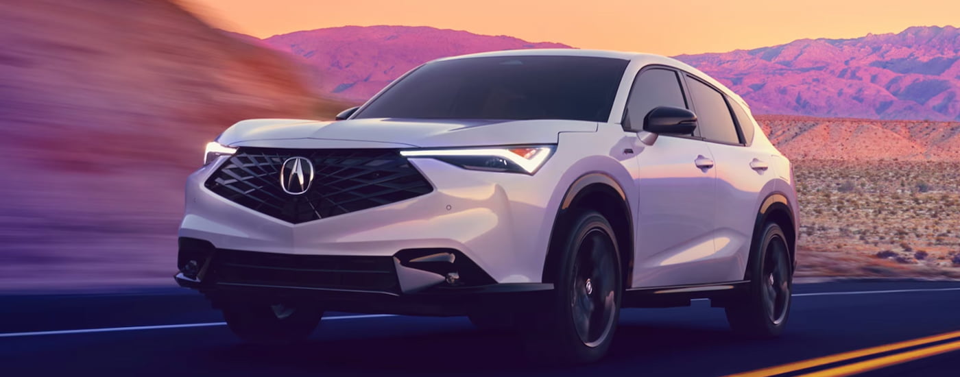 White 2026 Acura ADX driving down an open road.