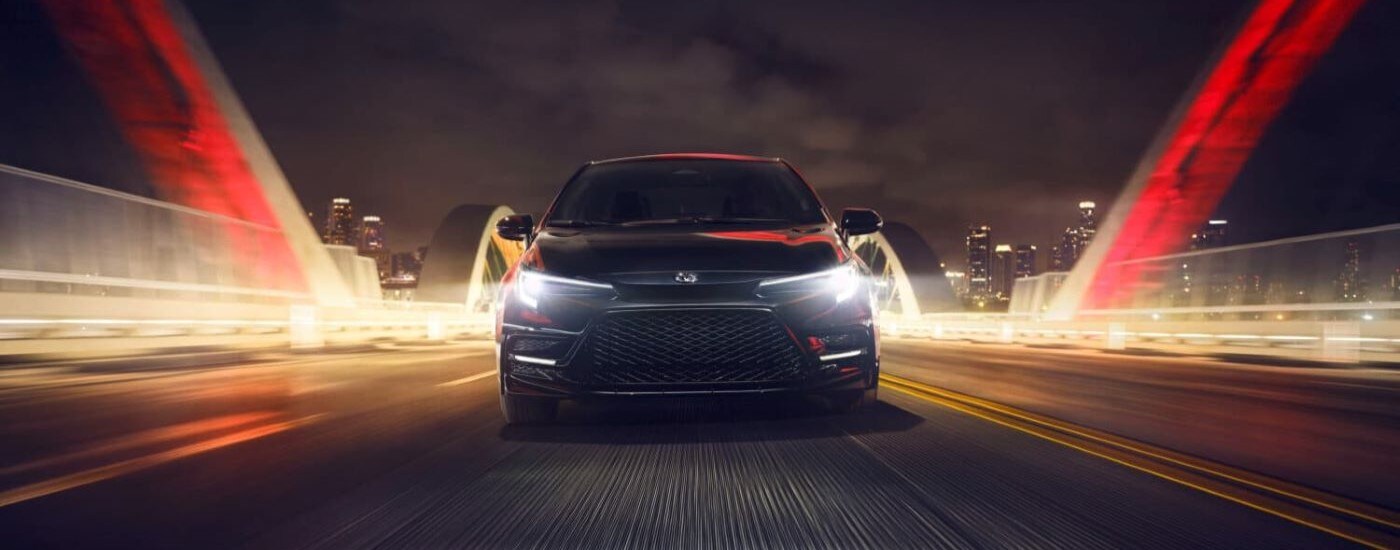 Black 2026 Toyota Corolla driving across a bridge.