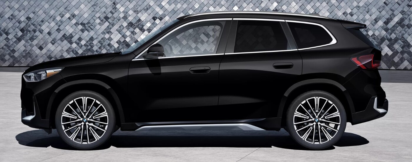 2026%20BMW%20X1%20-side.png Side view of a black 2026 BMW X1
