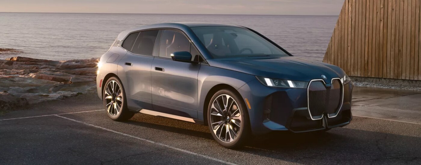 2026%20BMW%20iX%20-%20water.png Grey 2026 BMW iX backed into a spot by water