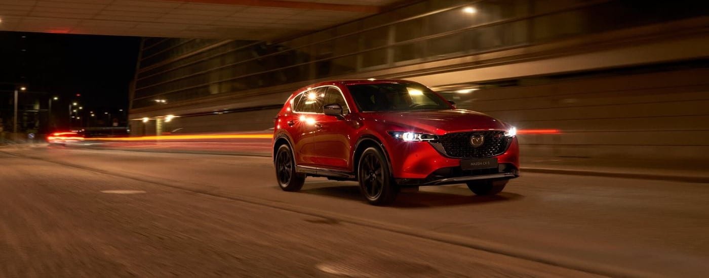 2023%20Mazda%20CX-5%20-%20Night%20(2).jpg A red 2023 Mazda CX-% is shown driving at night.