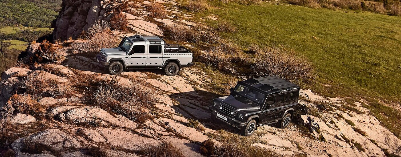 Ineos Grenadier - duo.png A white and a black 2025 INEOS Grenadier parked off road fater looking at a INEOS Grenadier for Sale Near Myrtle Beach