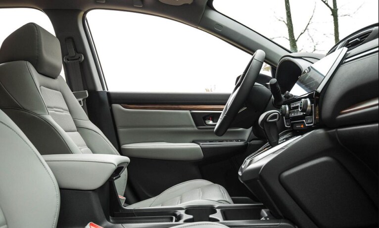 2023-honda-cr-v-2.png A view of the interior cabin of the 2023 Honda CR-V upholstered in light gray leather and a dark gray cabin